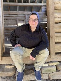 Portrait of woman sitting outside hut