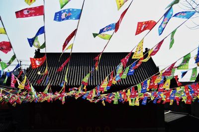 Low angle view of flags hanging against sky