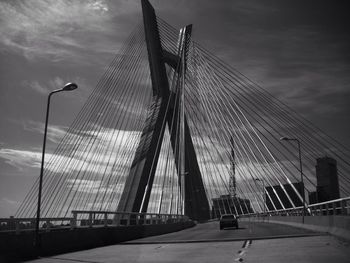 Bridge over river against cloudy sky