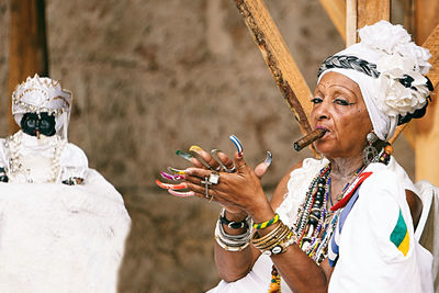 Portrait of senior woman wearing traditional clothing smoking cigar