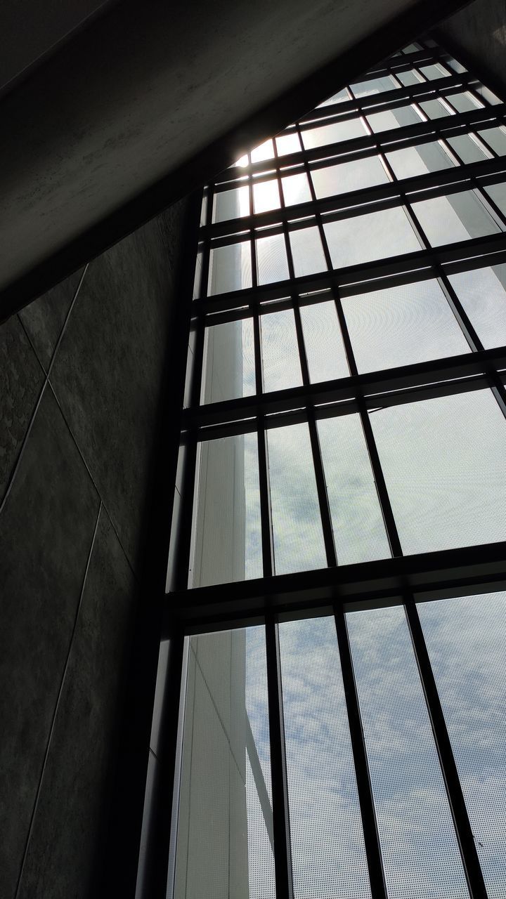 LOW ANGLE VIEW OF SKYLIGHT AGAINST SKY SEEN THROUGH GLASS WINDOW