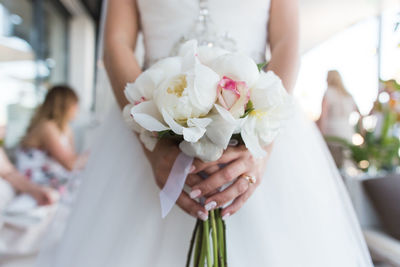 Midsection of woman holding flower bouquet