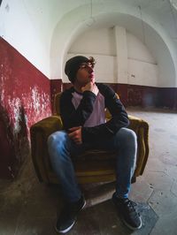 Young man sitting in corridor