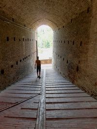 Rear view of boy walking in corridor of building