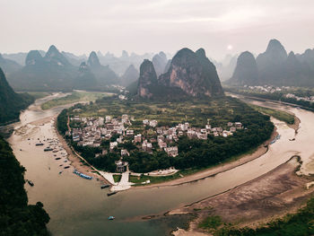 Aerial view of townscape by mountain against sky