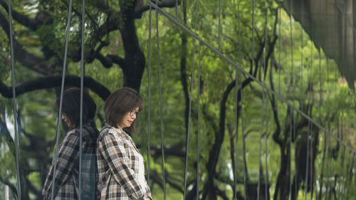 Side view of woman standing in forest