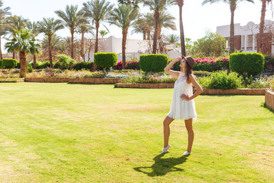 Fashionable young woman wearing white dress while standing in park