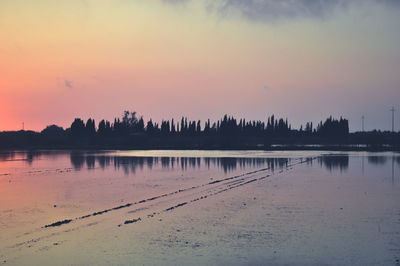 Scenic view of lake against romantic sky at sunset