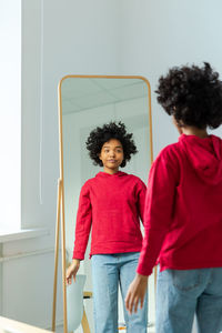 Rear view of young woman standing against sky