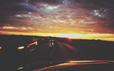 Road passing through dramatic sky during sunset