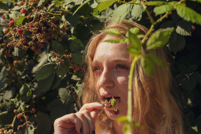 Close-up of thoughtful woman against plants