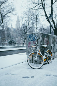 Snow-covered bicycle and footprints in the snow against the backdrop of the old town hall