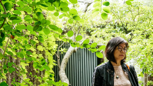 Portrait of woman standing against plants