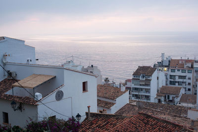 High angle view of townscape by sea against sky