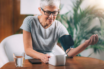 Mid adult man sitting on table at home