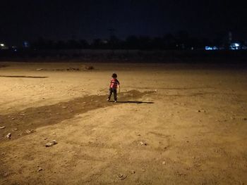 Full length of boy on field at night