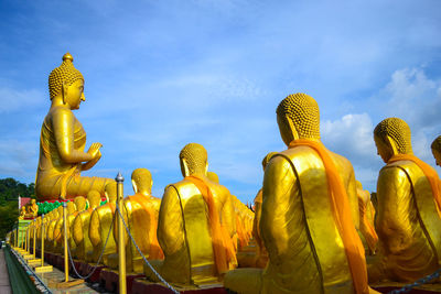 Low angle view of buddha statue against sky