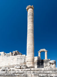 Low angle view of old ruins against clear blue sky