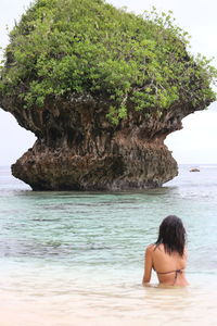 Young woman looking at sea against sky