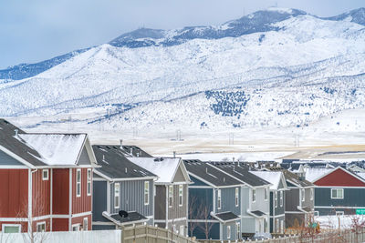 Houses on snowcapped mountain against sky