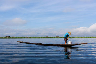 Scenic view of man standing on canoe