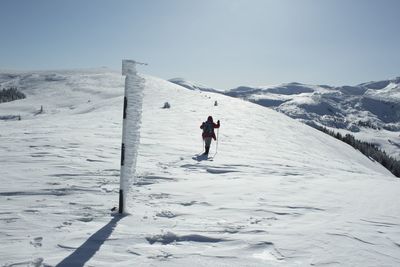 People on snow covered mountain against sky