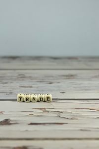 Close-up of text on table at beach against sky