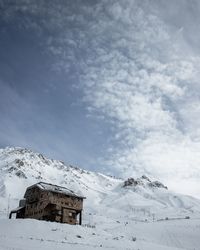Low angle view of building on snow covered land against sky