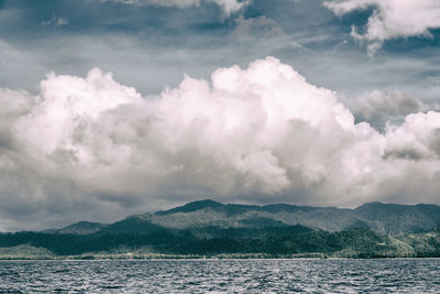 Scenic view of sea and mountains against sky