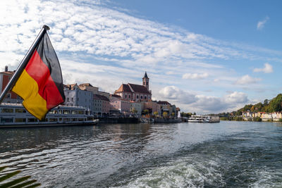 View at passau during a ship excursion in autumn with the german flag in foreground