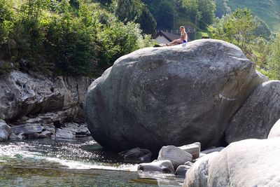 Rear view of man on rock by water