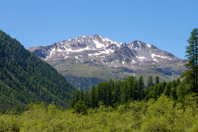 Scenic view of mountains against blue sky