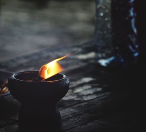 Close-up of lit candle on wood