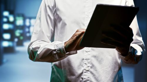 Midsection of businessman using digital tablet