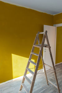 View of ladder against yellow wall