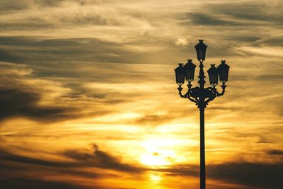 Silhouette of street light against dramatic sky