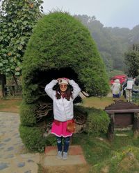 Portrait of woman standing against plants