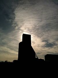 Silhouette of building against sky at sunset