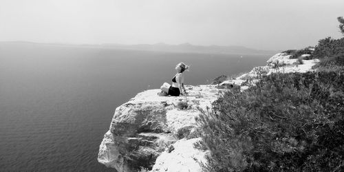 Rear view of woman standing on rock