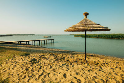 Gazebo on beach against clear sky