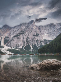 Scenic view of lake by snowcapped mountains against sky