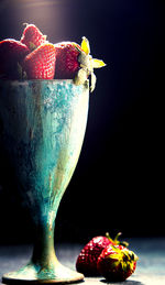 Close-up of strawberries on table against black background