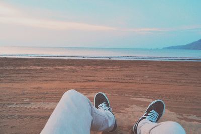 Low section of person relaxing at beach