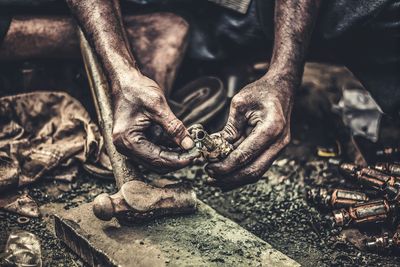 Midsection of worker holding machine part