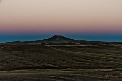 Scenic view of desert against sky during sunset