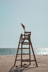 Lifeguard hut on beach against clear sky