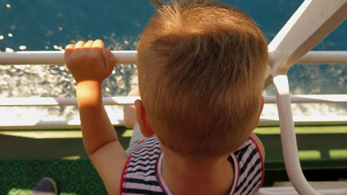 Rear view of boy by sea