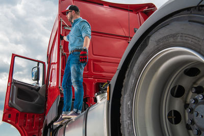 Side view of man standing on truck