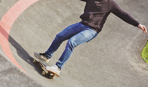 Low section of man skateboarding on street