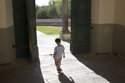 Rear view of man walking by building